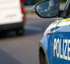 Polizeiauto im Vordergrund, weißer Lieferwagen auf der Straße im Hintergrund