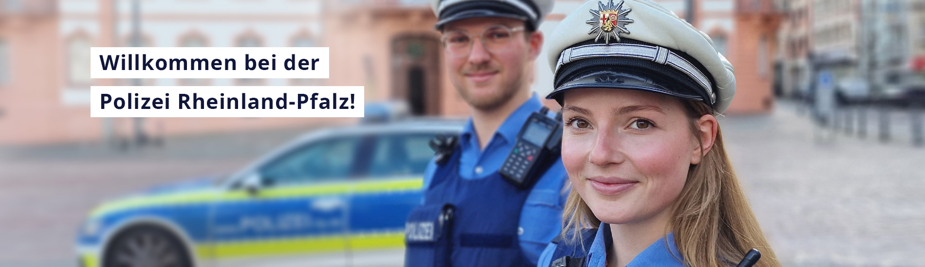 Polizistin und Polizist in Uniform. Aufschrift: Willkommen bei der Polizei Rheinland-Pfalz